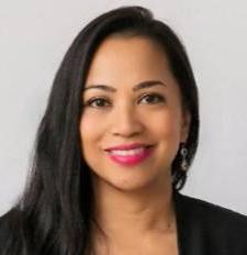 Woman with dark hair and pink lipstick wearing a black blazer